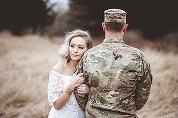 picture of woman holding a soldiers arm